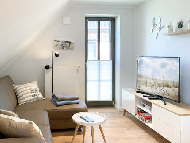 Strandglück Wohnbereich mit heller Couch und TV