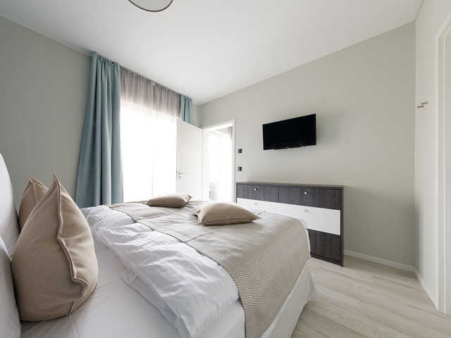 Schlafzimmer mit Doppelbett und Tv