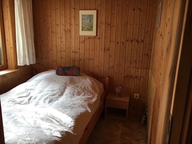 Schlafzimmer mit Doppelbett und begehbaren Schrank