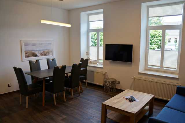 Kurhaus Nordstrand - exklusive Ferienwohnung 45494 Wohnzimmer mit Sitzecke (Schlafsofa) und Essecke