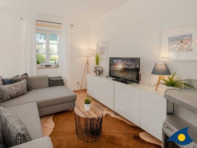 Wohnbereich mit Couch, Kamin und TV