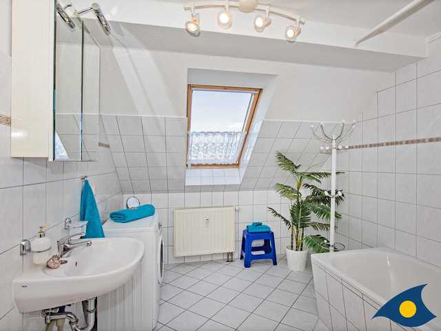 Badezimmer mit Badewanne, Waschmaschine und WC