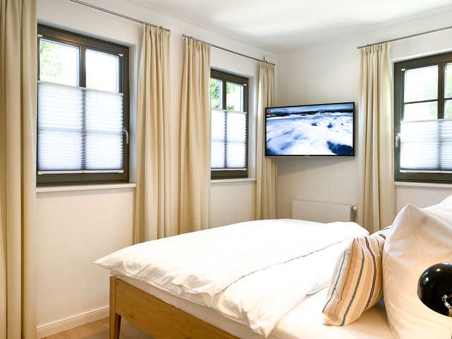 Schlafzimmer mit Doppelbett und TV