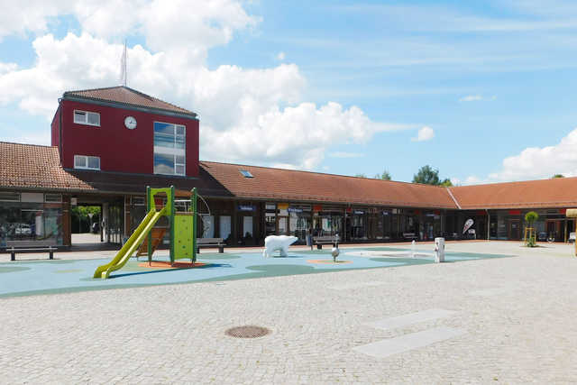 Der Marktplatz mit Geschäften und Spielplatz