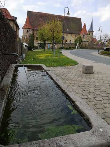 Dorfbrunnen mit Schloss