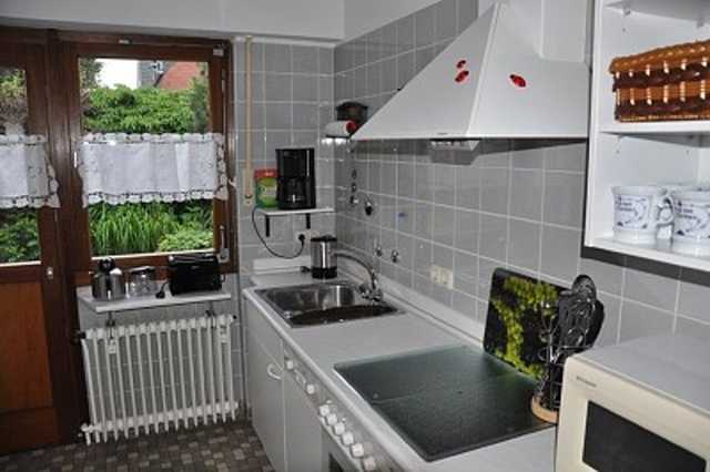 Küche mit Einbauküche und Zugang zur Terrasse