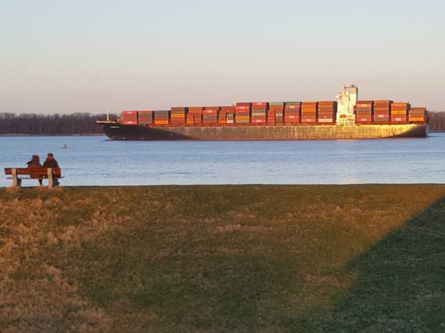 Ein Containerschiff zieht am Haus vorüber