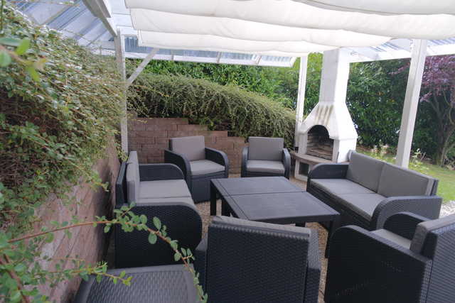 Die Terrasse mit den Lounge-Möbeln und Kamin, d...