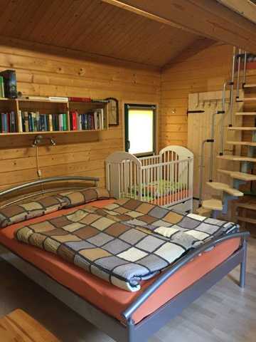 Schlafzimmer mit Doppelliege und Kinderbett