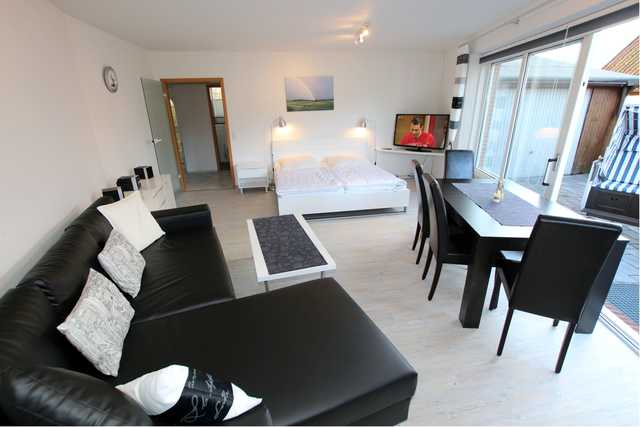 Wohnzimmer mit Doppelbett, Essplatz, Sofa und Z...