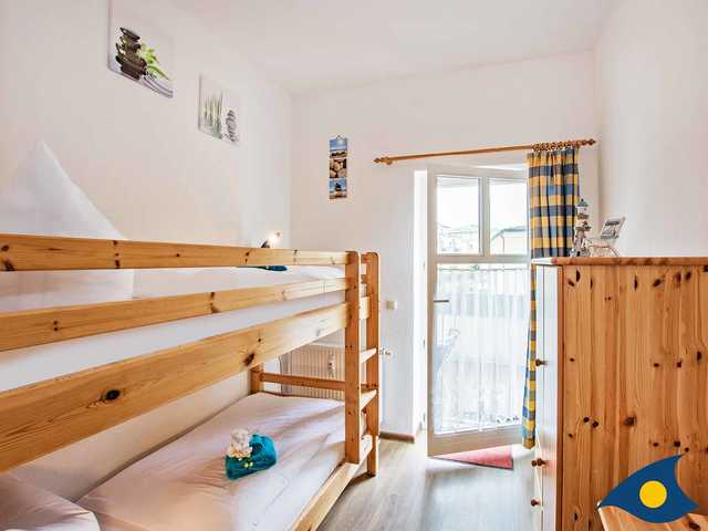 Kinderzimmer mit Etagenbett und Zugang zum Balkon