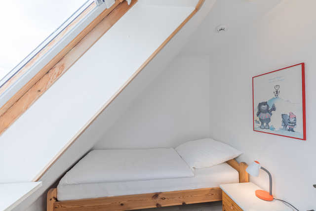 Schlafzimmer mit einem Einzelbett im Obergeschoss
