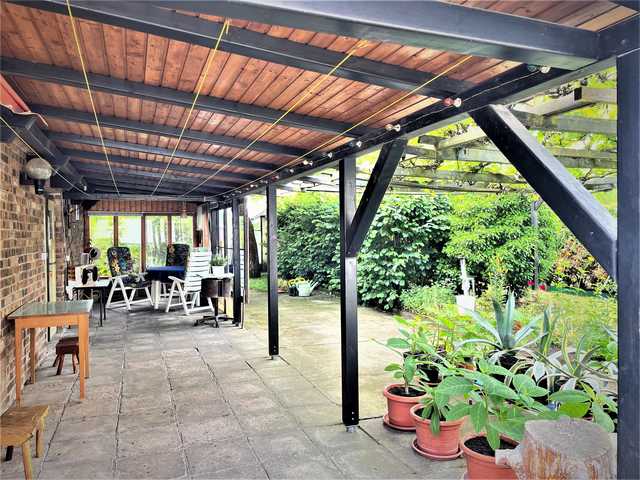 große überdachte Terrasse mit Gartenmöbeln
