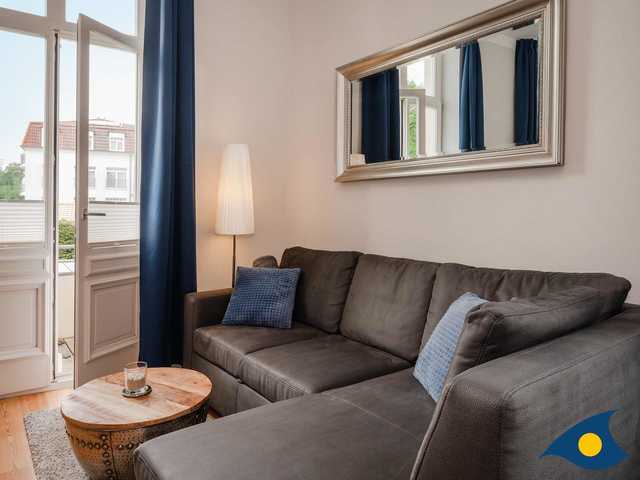Wohnbereich mit Couch und Blick auf Balkon